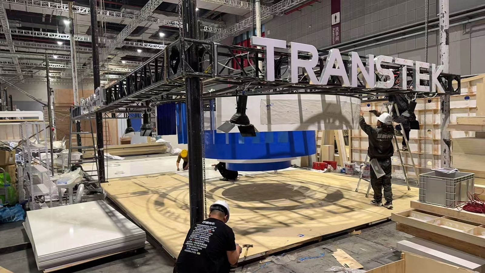 Crew rigging the overhead truss and sign at the venue